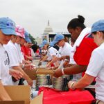 United Way volunteers stuffing backpacks w books (edit out 2011)